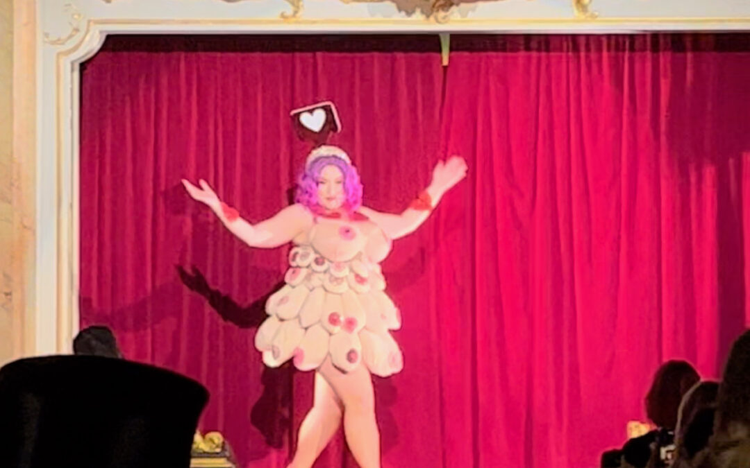 A lady on stage in a dress made of boobs.